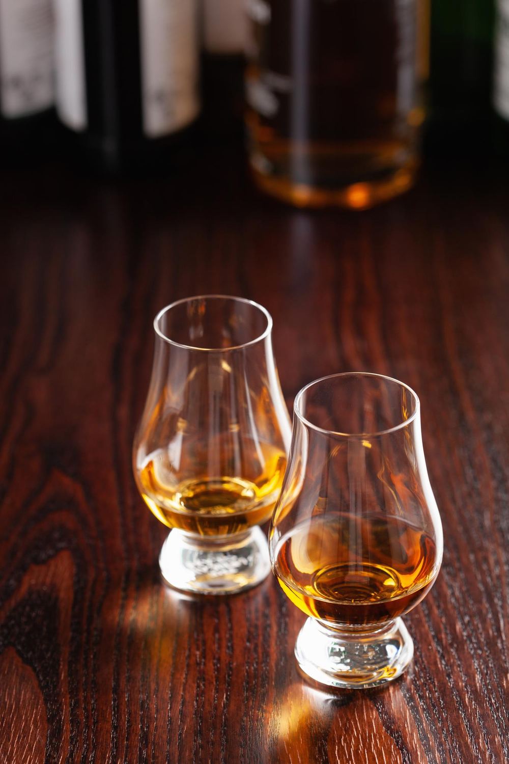 Two whisky glasses on wood